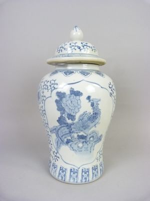 un vase bleu et blanc avec un couvercle posé sur une table