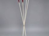 three white and red sticks are standing on a white stand