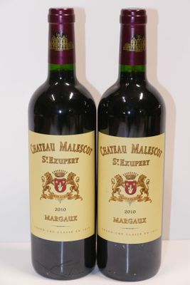 deux bouteilles de vin rouge posées sur une table blanche