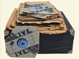 a stack of old records sitting on top of a suitcase