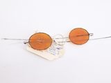 pair of orange tinted glasses on a white background with a piece of paper
