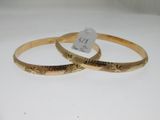 deux bracelets en or présentant des motifs gravés sur un fond blanc