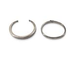 une paire de boucles d'oreilles créoles en argent sur fond blanc