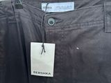 black pants hanging on a rack in front of a window
