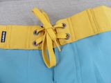 the back of a person wearing a yellow belt and blue shorts