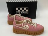 the pink shoes are next to a black box with a name on it