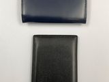 two black leather wallets sitting next to each other on a white surface