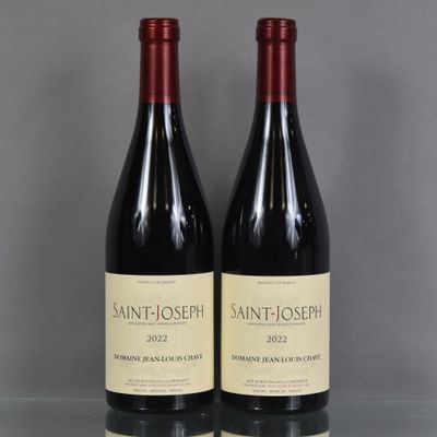 deux bouteilles de vin sont posées sur une table en verre