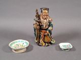 une figurine représentant un homme avec un chapeau et un bol