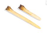 two wooden sticks that are next to each other on a white surface