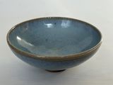 un bol bleu posé sur une table blanche