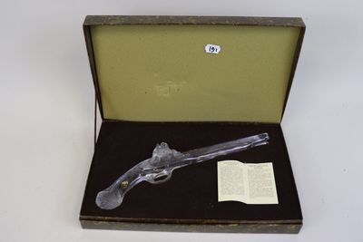 un pistolet dans une boîte contenant un livre
