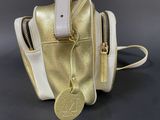 the gold and white purse is sitting on a black surface