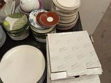 many plates and bowls sitting on a table next to each other
