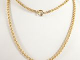 a close up of a gold necklace on a mannequin mannequin