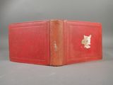 a red book with a gold leaf on it