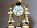 une horloge posée sur un support sur une table