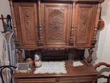 une armoire en bois et deux chaises dans une pièce