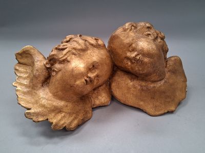 une paire de figurines d'anges en or sur fond blanc