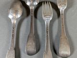 quatre cuillères et une fourchette sont posées sur une table