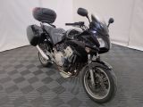 une moto noire garée sur un sol à damier