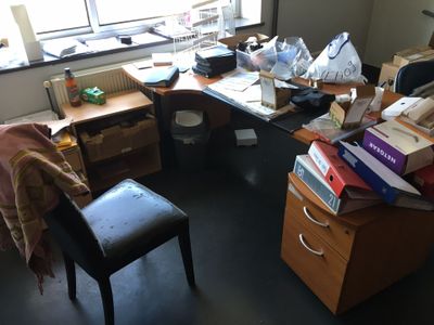 une chaise placée devant un bureau sur lequel se trouvent de nombreuses boîtes