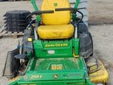a picture of a green and yellow lawn mower parked in a lot