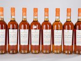 six bouteilles de vin alignées sur une surface blanche