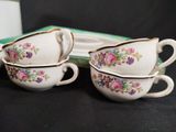 two cups and saucers are sitting on a table next to a box