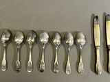 a lot of spoons and forks laid out on a table