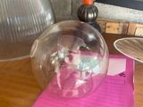 une boule de verre posée sur un bureau, à côté d'un bloc-notes et d'une lampe