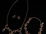 un gros plan d'un collier et d'un bracelet posés sur une surface noire