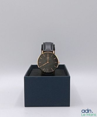 montre noire et dorée dans un coffret noir sur fond blanc