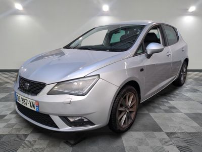 une voiture argentée garée dans une pièce au sol en damier
