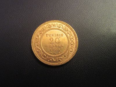 gros plan d'une pièce d'or sur une surface noire