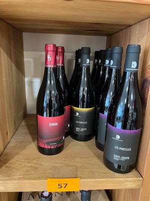 plusieurs bouteilles de vin sur une étagère dans un magasin