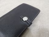 a black leather case with a button on it