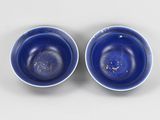 pair of blue bowls with gold flakes on them on a white surface