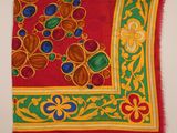 un gros plan sur une écharpe rouge et verte ornée de motifs colorés