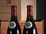 two bottles of wine sitting next to each other on a table