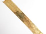 a close up of a gold bracelet on a white surface