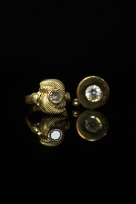 a close up of a pair of gold cufflinks with diamonds