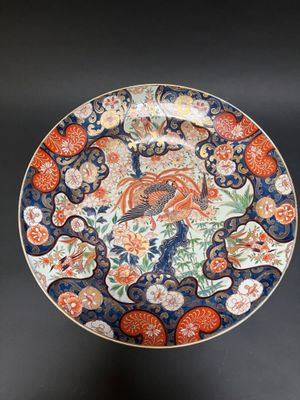 a close up of a plate on a black surface with flowers