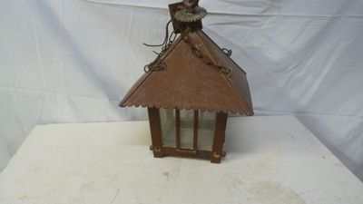 a small wooden birdhouse with a bird on top of it