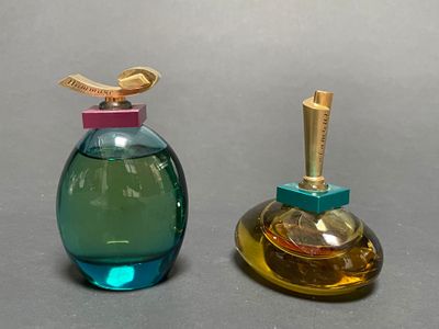 two bottles of perfume sitting next to each other on a table