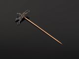 a small metal stick with a bird on it sitting on a black surface