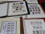 beaucoup de livres posés sur une table, sur lesquels sont apposés de nombreux timbres