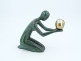 a figurine of a man holding a golden object