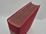 the red book is sitting on a white surface with a white background