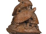 une image représentant une sculpture en bois représentant une tortue et une tortue posée sur une carapace de tortue